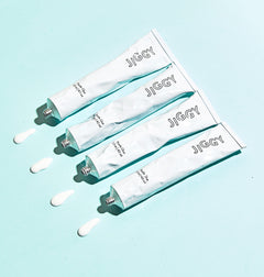 Jiggy puzzles glue tubes on blue background