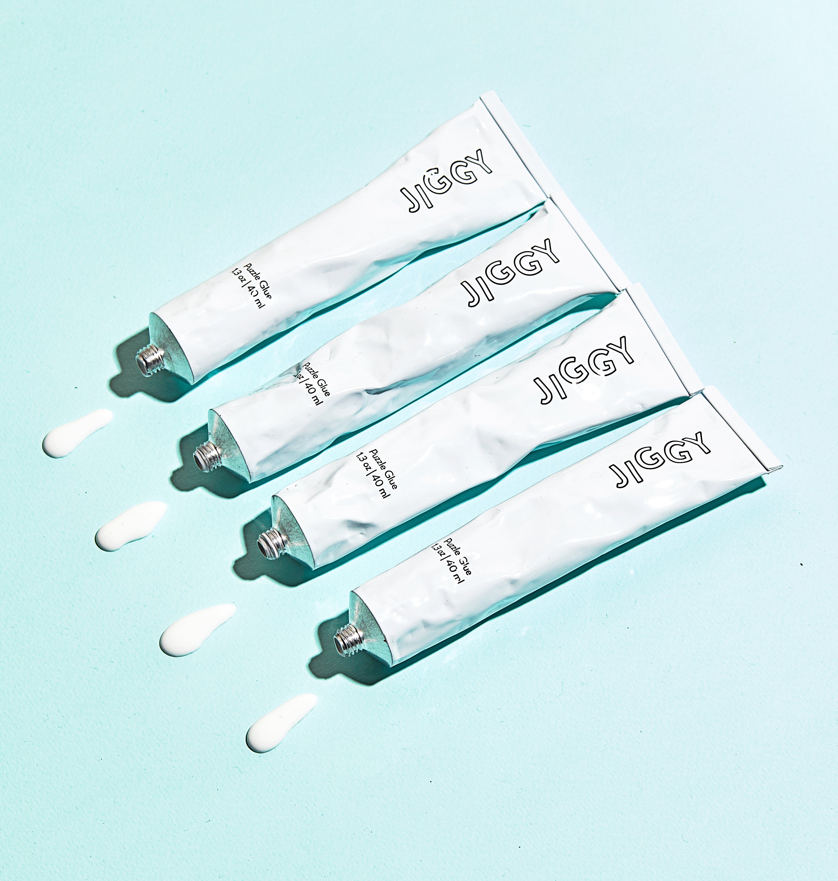 Jiggy puzzles glue tubes on blue background