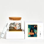 Reyna artwork puzzle box with reusable glass jar, tube of puzzle glue and straight-edge tool to spread the glue.