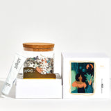 Reyna artwork puzzle box with reusable glass jar, tube of puzzle glue and straight-edge tool to spread the glue.