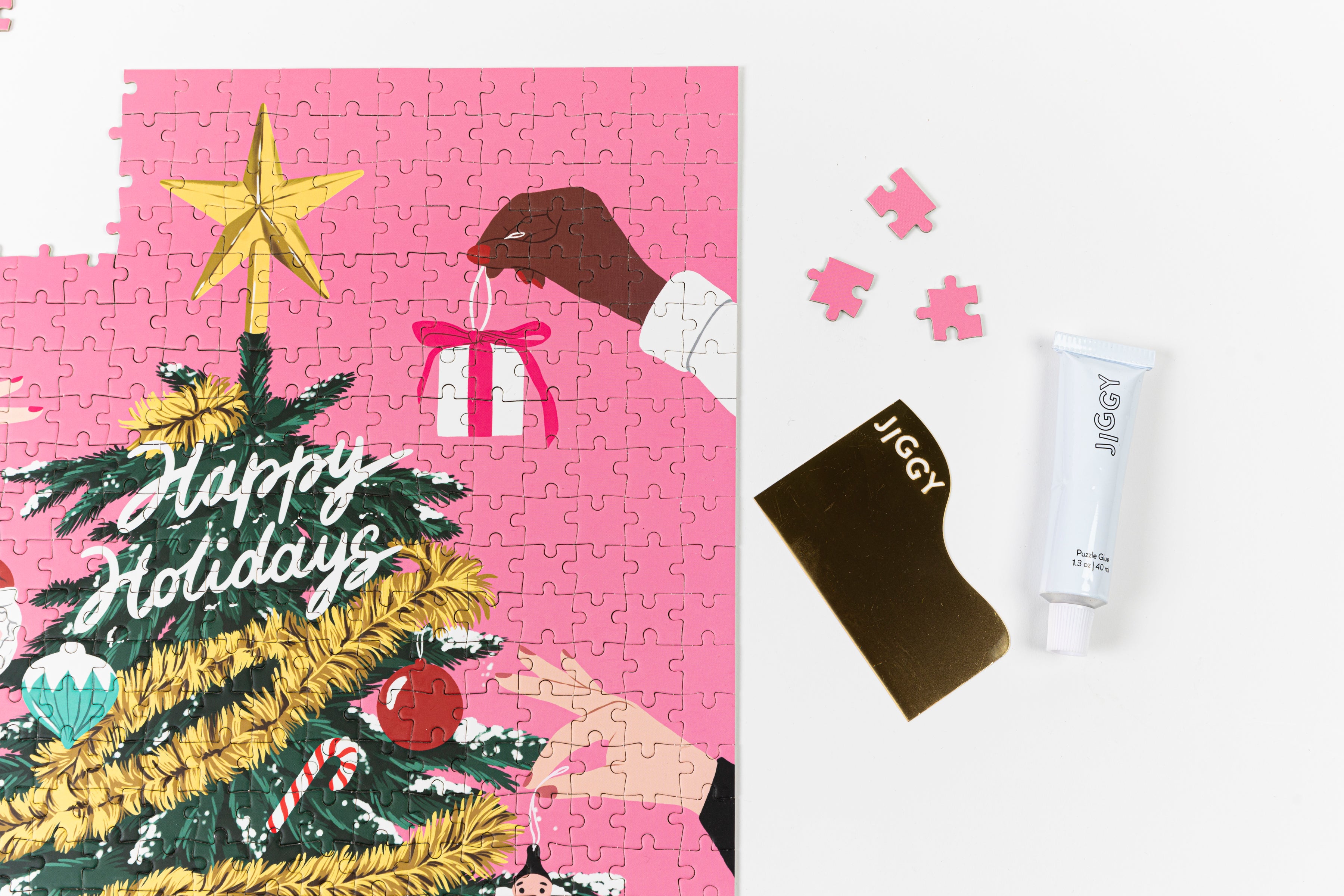 Near completed Puzzle with a tube of puzzle glue and straight-edge tool to spread the glue.