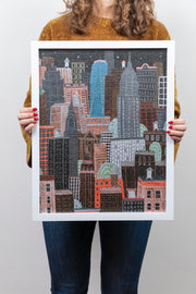 Women holding completed and framed NYC Night puzzle
