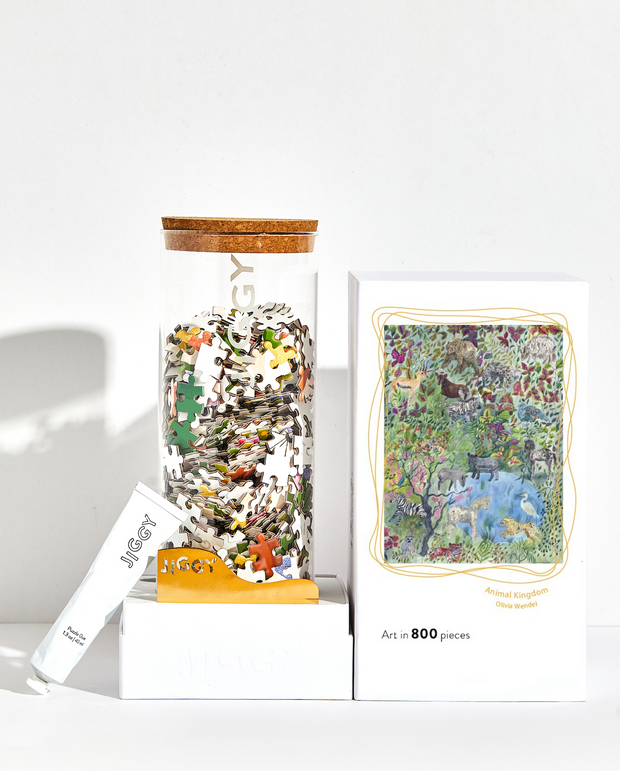 Animal Kingdom Puzzle box with reusable glass jar, tube of puzzle glue and straight-edge tool to spread the glue.