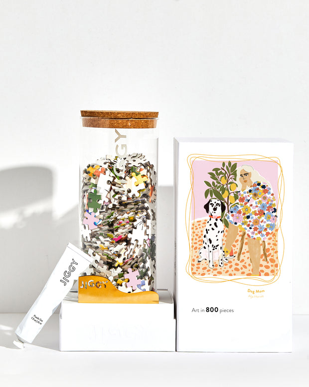 Dog Mom artwork puzzle box with reusable glass jar, tube of puzzle glue and straight-edge tool to spread the glue.